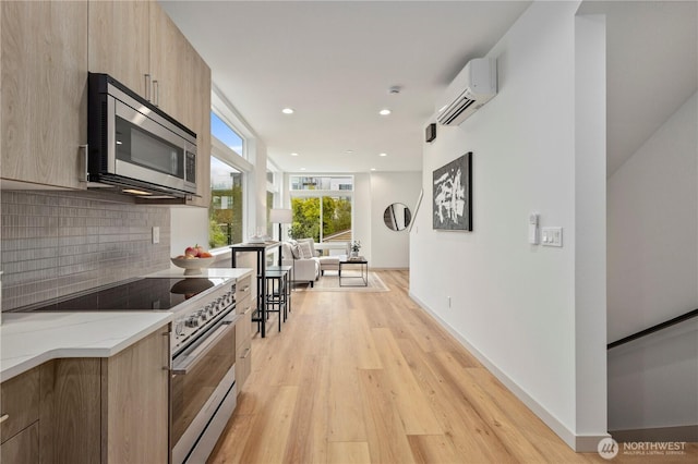 7013 9th Ave NE, Seattle, WA 98115 - kitchen with stainless steel microwave, electric range oven, a wall mounted air conditioner, modern cabinets, and tasteful backsplash