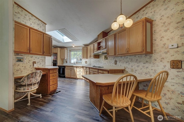 1754 NE Mesford Rd Unit 71, Poulsbo, WA 98370 - kitchen featuring wallpapered walls, a peninsula, dark wood-style floors, under cabinet range hood, and black appliances