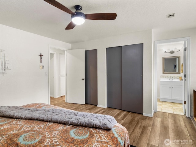 4607 225th Street Ct E, Spanaway, WA 98387 - bedroom with two closets, wood finished floors, ensuite bath, and a ceiling fan