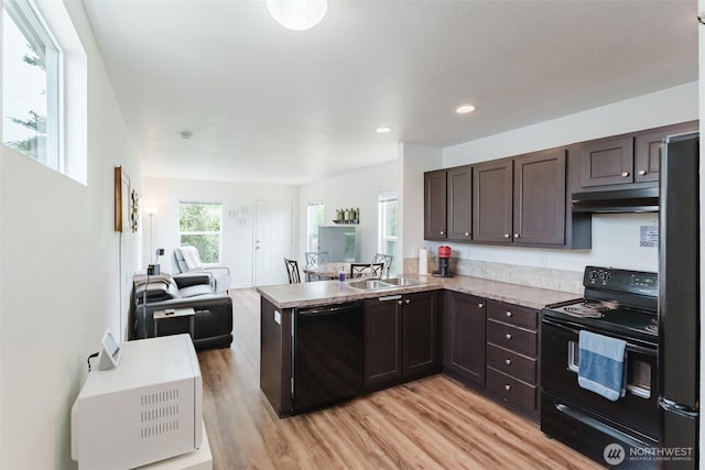 7543 Wooldridge Dr, Blaine, WA 98230 - kitchen with black appliances, dark brown cabinets, light wood-style floors, a peninsula, and under cabinet range hood