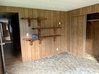 818 D St, Vader, WA 98593 - unfurnished bedroom featuring wood walls and a closet