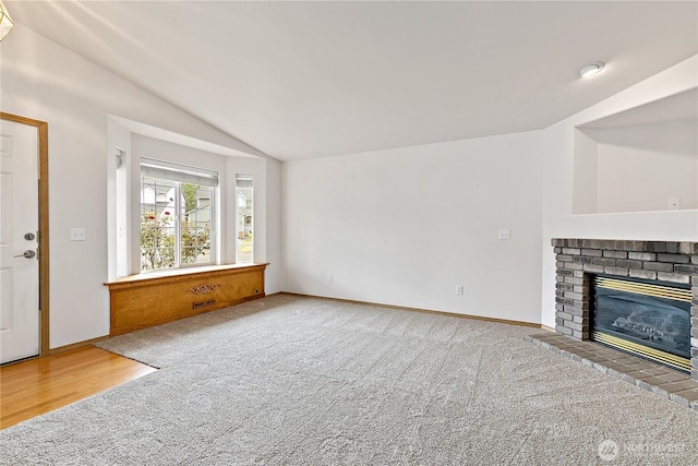8803 136th St E, Puyallup, WA 98373 - unfurnished living room with lofted ceiling, carpet flooring, and a brick fireplace