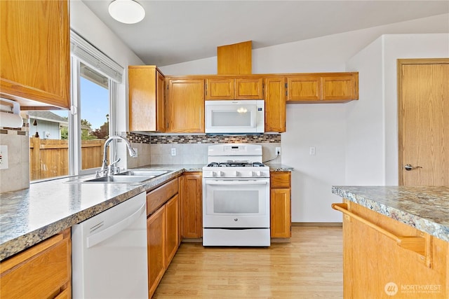 8803 136th St E, Puyallup, WA 98373 - kitchen featuring white appliances, light wood-style floors, brown cabinetry, backsplash, and lofted ceiling