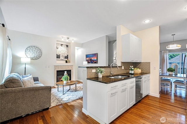 6707 SE Cougar Mountain Way Unit 2, Bellevue, WA 98006 - kitchen featuring open floor plan, stainless steel dishwasher, light wood-style flooring, dark stone countertops, and white cabinetry