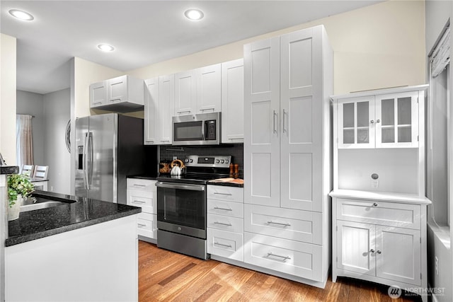 6707 SE Cougar Mountain Way Unit 2, Bellevue, WA 98006 - kitchen with stainless steel appliances, light wood-style floors, decorative backsplash, recessed lighting, and white cabinets