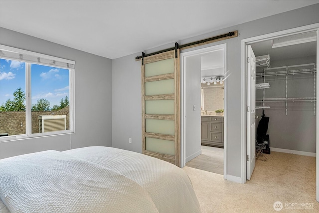 6707 SE Cougar Mountain Way Unit 2, Bellevue, WA 98006 - bedroom with a walk in closet, light colored carpet, a closet, a barn door, and ensuite bath