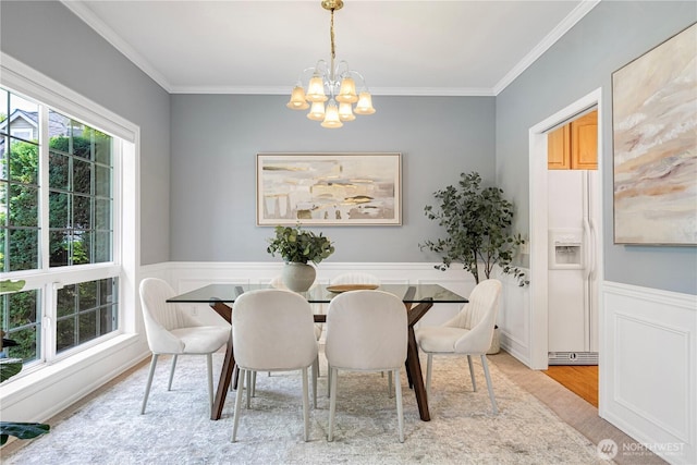 1912 243rd Pl SE, Bothell, WA 98021 - dining space featuring a chandelier, crown molding, a wainscoted wall, wood finished floors, and a decorative wall