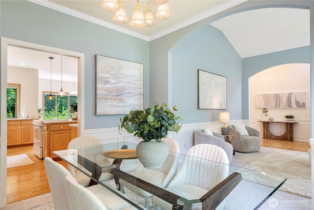 1912 243rd Pl SE, Bothell, WA 98021 - dining room featuring a chandelier, light wood-style flooring, arched walkways, a wainscoted wall, and crown molding
