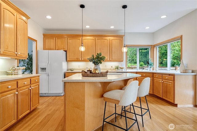 1912 243rd Pl SE, Bothell, WA 98021 - kitchen featuring white fridge with ice dispenser, light wood-style floors, a center island, a breakfast bar, and recessed lighting