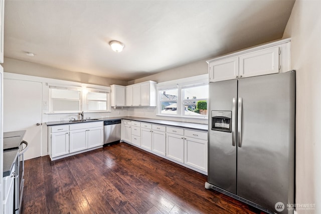 1306 Main St, Sumner, WA 98390 - kitchen featuring stainless steel appliances, dark countertops, dark wood finished floors, and white cabinets