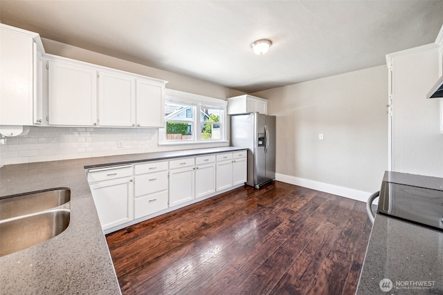 1306 Main St, Sumner, WA 98390 - kitchen with stainless steel fridge with ice dispenser, white cabinetry, dark wood-style flooring, range, and light stone counters