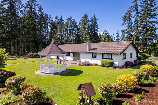 9802 124th St E, Puyallup, WA 98373 - rear view of property featuring a gazebo, stucco siding, a chimney, and view of scattered trees
