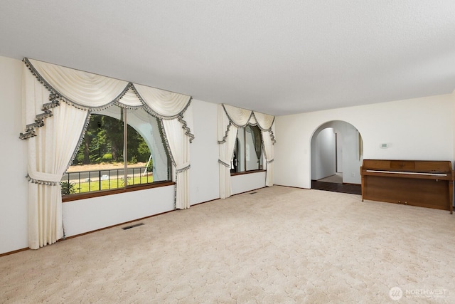 9802 124th St E, Puyallup, WA 98373 - spare room featuring arched walkways and carpet