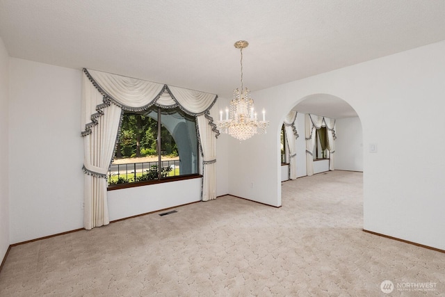 9802 124th St E, Puyallup, WA 98373 - unfurnished room with a chandelier, arched walkways, and carpet flooring