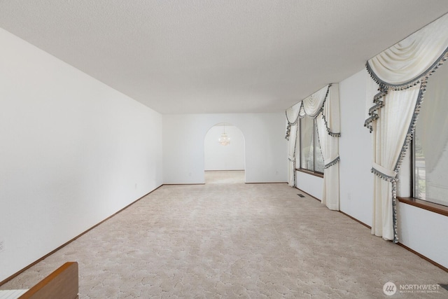 9802 124th St E, Puyallup, WA 98373 - carpeted empty room featuring arched walkways and a chandelier