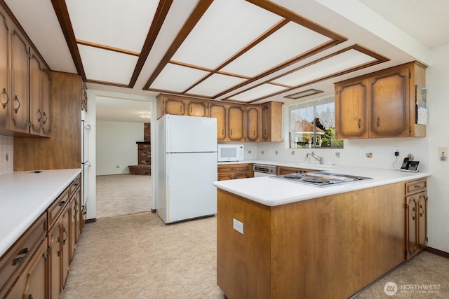 9802 124th St E, Puyallup, WA 98373 - kitchen with white appliances, brown cabinets, a peninsula, and light countertops