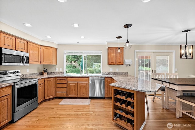 1920 11th Street Pl SW, Puyallup, WA 98371 - kitchen with stainless steel appliances, a peninsula, crown molding, light stone countertops, and pendant lighting