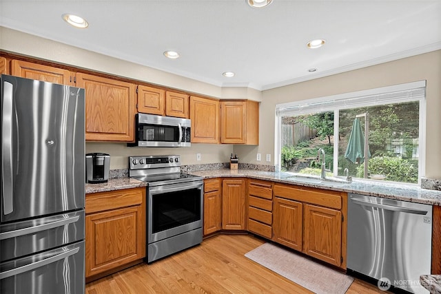 1920 11th Street Pl SW, Puyallup, WA 98371 - kitchen with stainless steel appliances, light stone countertops, light wood-style flooring, crown molding, and recessed lighting