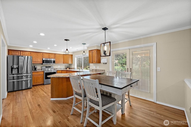 1920 11th Street Pl SW, Puyallup, WA 98371 - kitchen featuring stainless steel appliances, light wood-type flooring, brown cabinets, recessed lighting, and decorative light fixtures