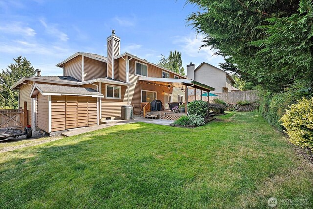 1920 11th Street Pl SW, Puyallup, WA 98371 - rear view of property featuring a fenced backyard, a chimney, and a patio