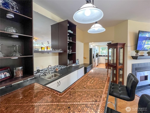 7806 Birch Bay Dr Unit 501, Blaine, WA 98230 - kitchen with open shelves, dark countertops, stainless steel fridge with ice dispenser, a fireplace, and hanging light fixtures