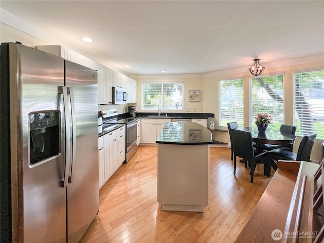 7806 Birch Bay Dr Unit 501, Blaine, WA 98230 - kitchen with stainless steel appliances, a center island, dark countertops, white cabinetry, and recessed lighting