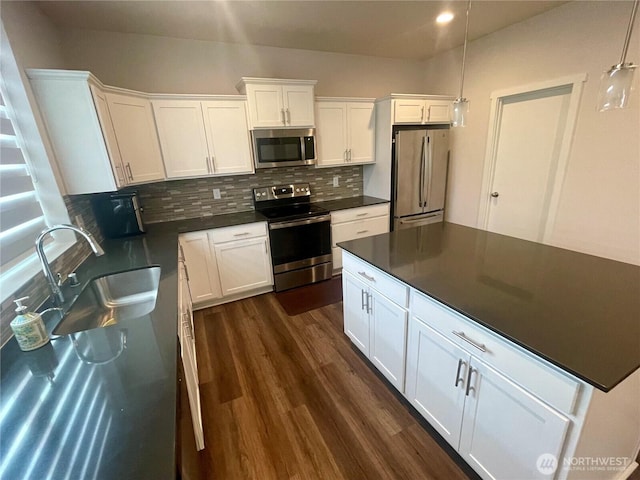 2129 Lancaster Way, Ferndale, WA 98248 - kitchen with appliances with stainless steel finishes, dark countertops, decorative backsplash, dark wood-type flooring, and white cabinetry