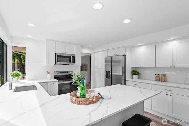 17805 NE 29th St, Redmond, WA 98052 - kitchen featuring appliances with stainless steel finishes, recessed lighting, backsplash, light stone countertops, and white cabinets