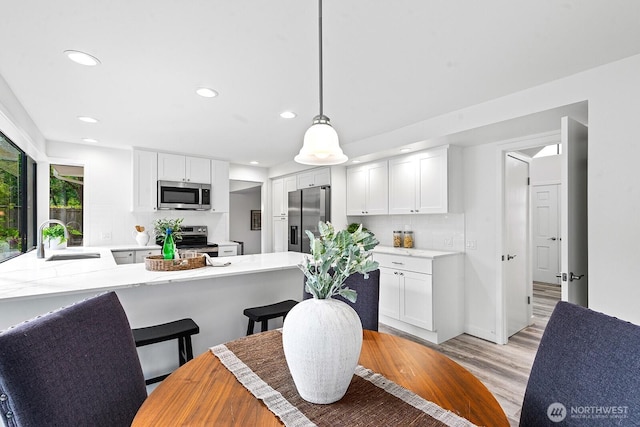 17805 NE 29th St, Redmond, WA 98052 - kitchen with appliances with stainless steel finishes, decorative backsplash, light wood-style flooring, recessed lighting, and white cabinetry
