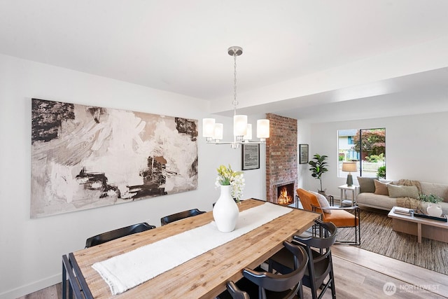 17805 NE 29th St, Redmond, WA 98052 - dining space featuring light wood-style flooring, a chandelier, and a large fireplace