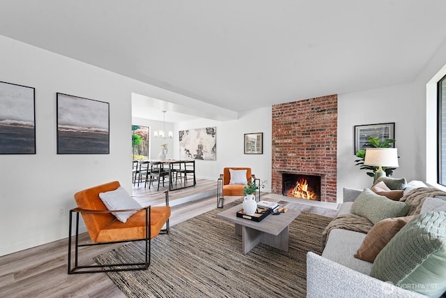 17805 NE 29th St, Redmond, WA 98052 - living room with wood finished floors, a chandelier, and a brick fireplace