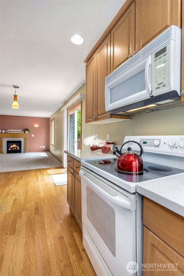 24212 13th Pl W, Bothell, WA 98021 - kitchen featuring white appliances, light countertops, light wood-style flooring, a lit fireplace, and recessed lighting