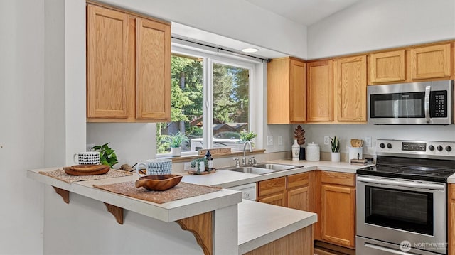 15725 Wallace Falls Loop Rd, Gold Bar, WA 98251 - kitchen featuring appliances with stainless steel finishes, light countertops, a breakfast bar, and a peninsula