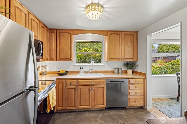 5065 SW Olga St, Seattle, WA 98116 - kitchen with appliances with stainless steel finishes, light countertops, and brown cabinetry