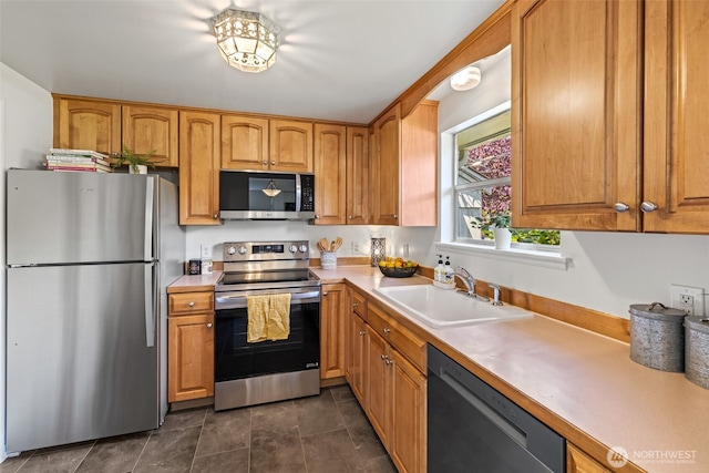 5065 SW Olga St, Seattle, WA 98116 - kitchen with appliances with stainless steel finishes, light countertops, and brown cabinetry