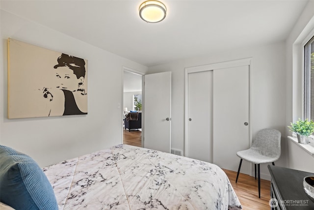 5065 SW Olga St, Seattle, WA 98116 - bedroom with multiple windows, wood finished floors, and a closet