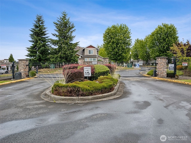 5909 Panorama Dr SE Unit 8-101, Auburn, WA 98092 - view of asphalt road featuring a gate, curbs, a gated entry, and traffic signs