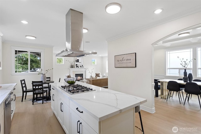 15006 Old Manor Way, Lynnwood, WA 98087 - kitchen with stainless steel appliances, island range hood, light wood finished floors, plenty of natural light, and ornamental molding