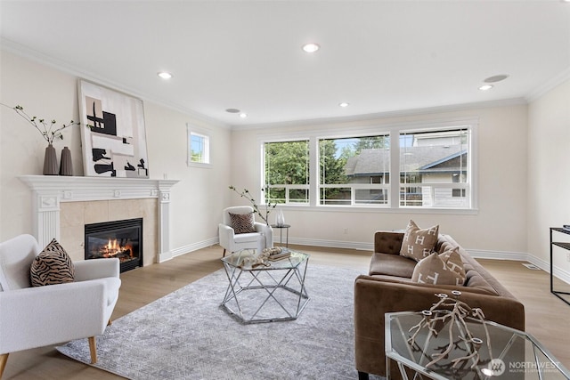 15006 Old Manor Way, Lynnwood, WA 98087 - living area featuring crown molding, light wood-style flooring, a tiled fireplace, and recessed lighting