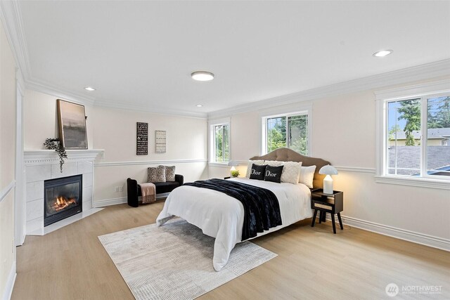 15006 Old Manor Way, Lynnwood, WA 98087 - bedroom with multiple windows, light wood-style floors, crown molding, a tiled fireplace, and recessed lighting