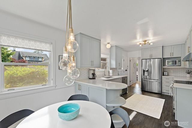 1604 28th Ave W, Seattle, WA 98199 - kitchen with stainless steel appliances, tasteful backsplash, gray cabinets, light countertops, and dark wood finished floors