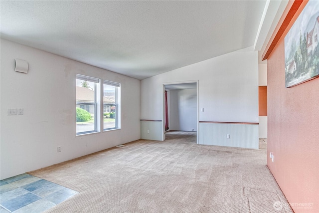 530 Sunday Dr, East Wenatchee, WA 98802 - carpeted spare room with a textured ceiling, lofted ceiling, and wainscoting