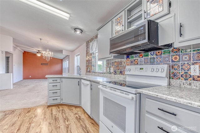 530 Sunday Dr, East Wenatchee, WA 98802 - kitchen with white appliances, a chandelier, a peninsula, tasteful backsplash, and light wood finished floors