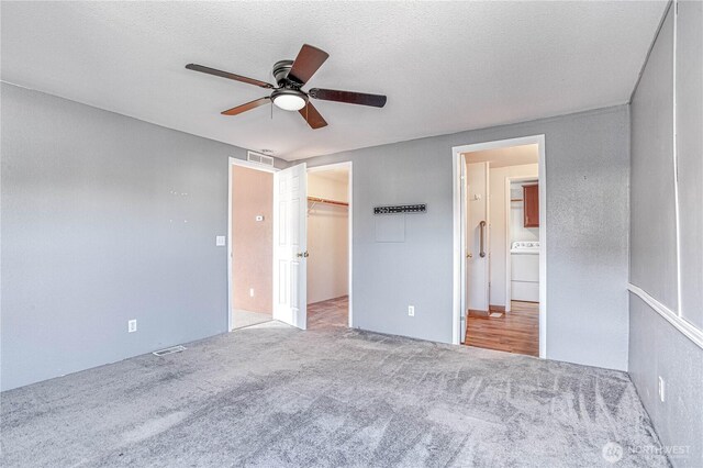 530 Sunday Dr, East Wenatchee, WA 98802 - unfurnished bedroom featuring washer / dryer, carpet flooring, a spacious closet, a ceiling fan, and a textured ceiling