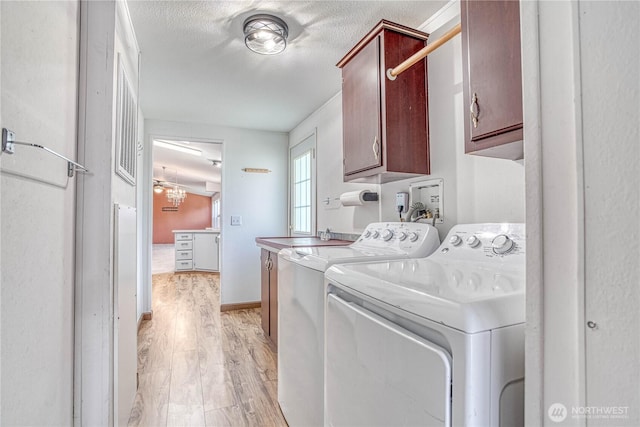 530 Sunday Dr, East Wenatchee, WA 98802 - laundry area with cabinet space, washing machine and dryer, light wood-style flooring, and a textured ceiling