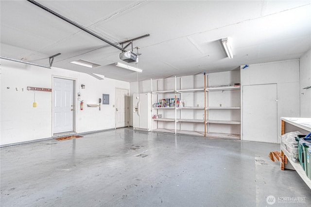 530 Sunday Dr, East Wenatchee, WA 98802 - garage with a garage door opener and white refrigerator with ice dispenser