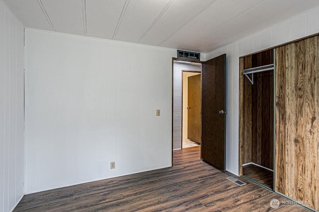 12614 113th Ave E Unit 247, Puyallup, WA 98374 - unfurnished bedroom with dark wood-type flooring, a closet, and wood walls