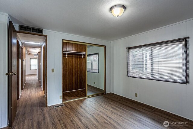 12614 113th Ave E Unit 247, Puyallup, WA 98374 - unfurnished bedroom featuring dark wood-type flooring, a closet, and multiple windows