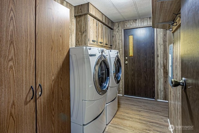 12614 113th Ave E Unit 247, Puyallup, WA 98374 - laundry area with washing machine and clothes dryer, cabinet space, wood walls, light wood-style floors, and a textured ceiling