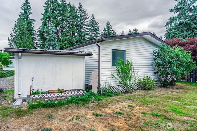 12614 113th Ave E Unit 247, Puyallup, WA 98374 - view of side of home with an outbuilding, a yard, and a metal roof
